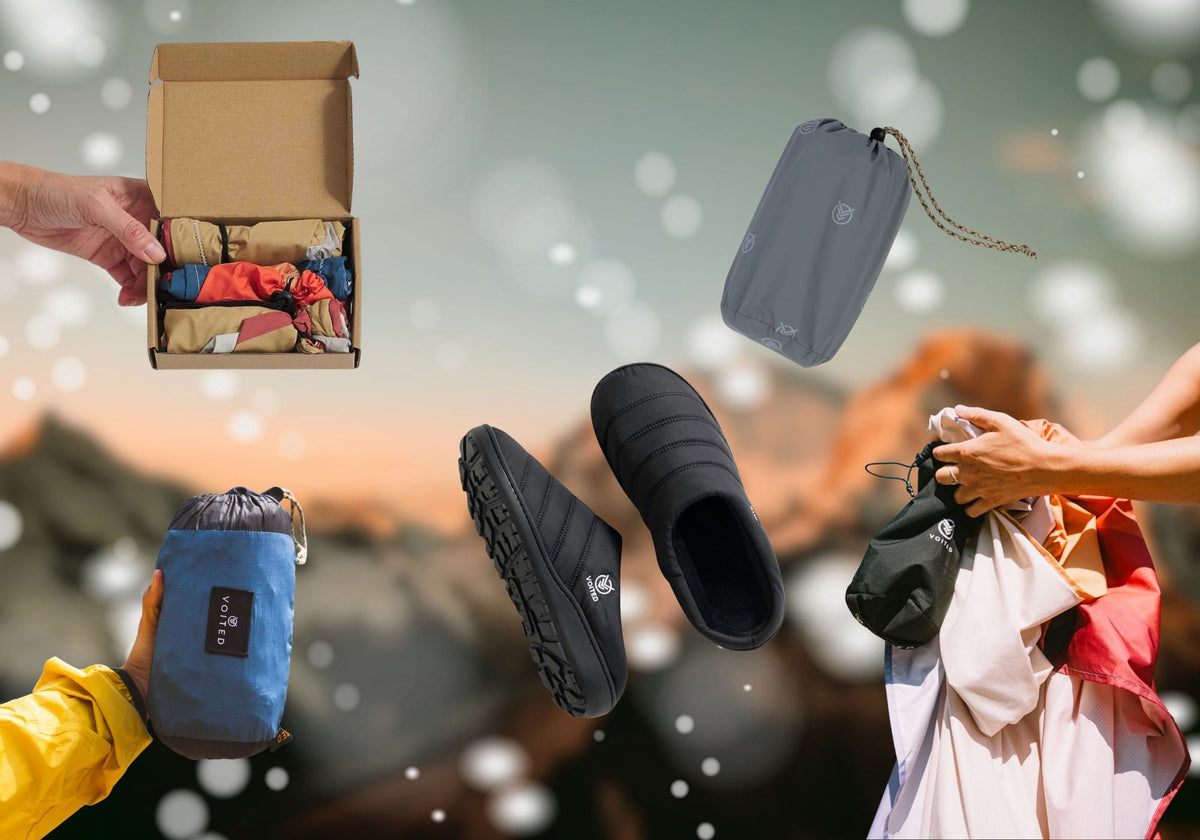 Collage von VOITED Produkten vor verschwommener Bergkulisse: schwarze Slipper, Liner in einer Geschenkbox, das Tout Pack und das Sandfree Beach Sheet in ihren kompakten Packbeuteln.