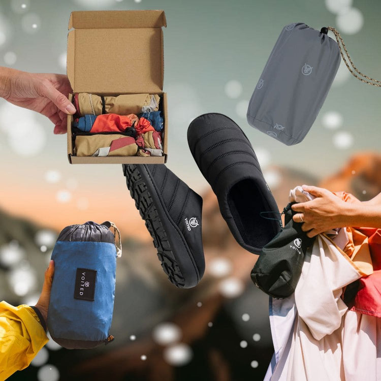 Collage von VOITED Produkten vor verschwommener Bergkulisse: schwarze Slipper, Liner in einer Geschenkbox, das Tout Pack und das Sandfree Beach Sheet in ihren kompakten Packbeuteln.